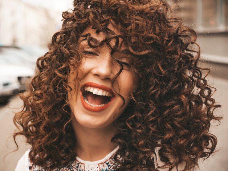 Retrato de la bella modelo sonriente con peinado afro rizos.