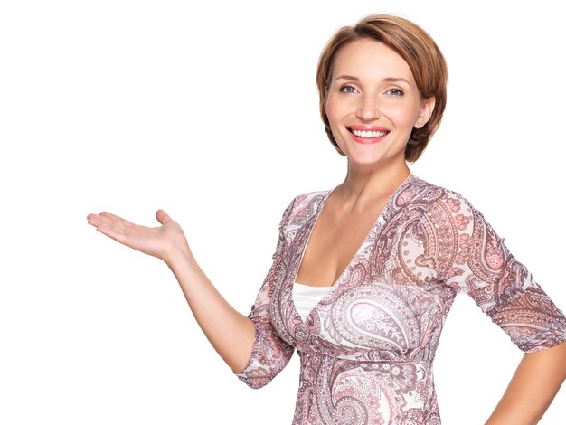 Retrato de una bella mujer adulta feliz con gesto de presentación en blanco