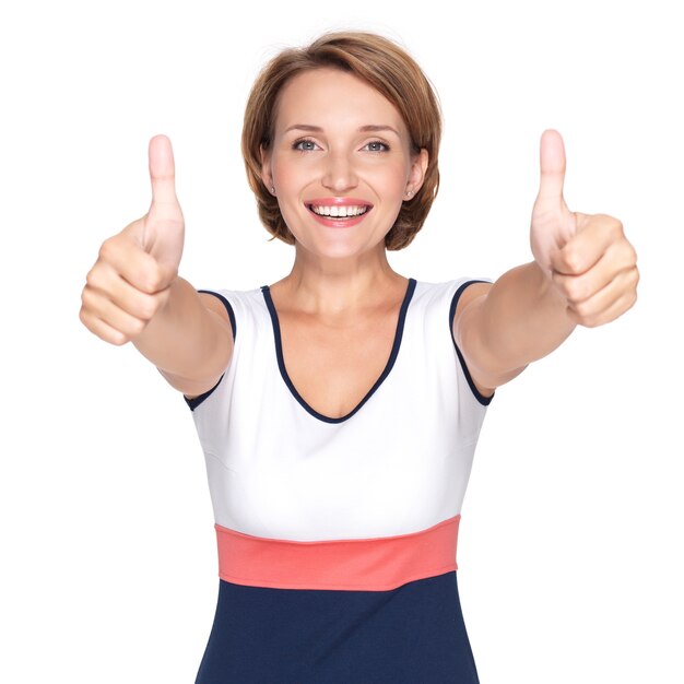 Retrato de una bella mujer adulta feliz con pulgar hacia arriba signo aislado en la pared blanca