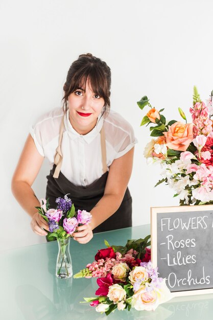 Retrato de una bella mujer arreglando flores en florero