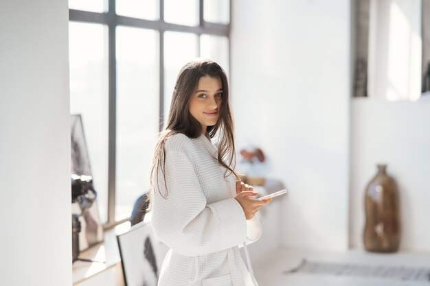 Retrato de una bella mujer en bata de baño en el interior