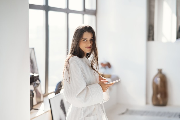 Retrato de una bella mujer en bata de baño en el interior