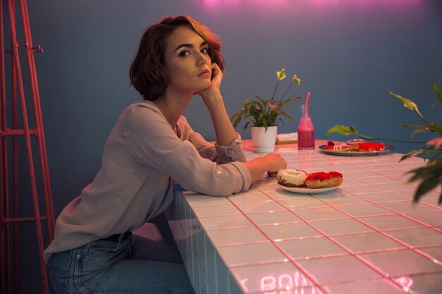 Retrato de una bella mujer desayunando en un café