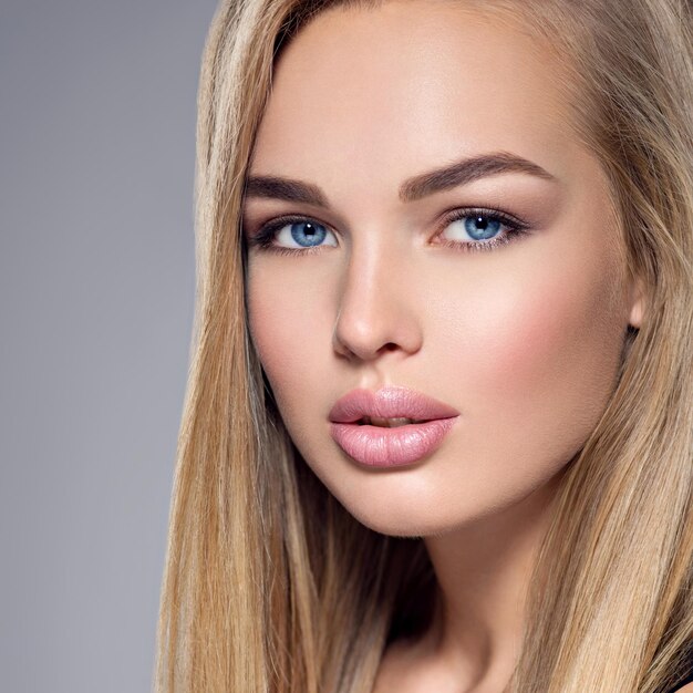 Retrato de una bella mujer joven con ojos azules y maquillaje marrón. Hermosa chica posando