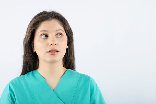 Retrato de una bella mujer joven en uniforme verde.