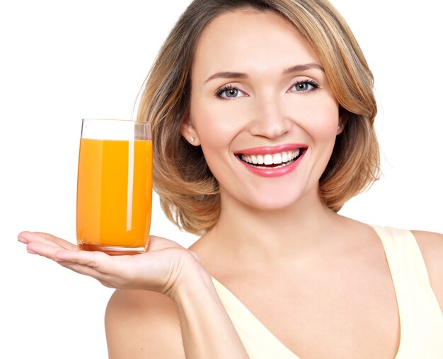 Retrato de una bella mujer joven con un vaso de jugo aislado en blanco.