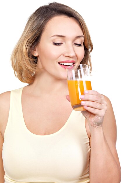 Retrato de una bella mujer joven con un vaso de jugo de naranja, aislado en blanco.