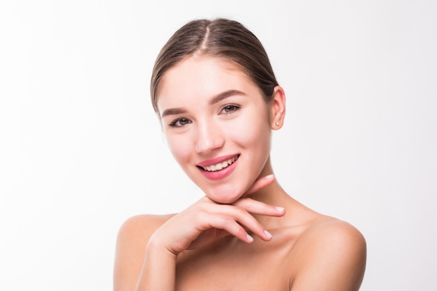 Retrato de una bella mujer con una piel perfecta en la pared blanca