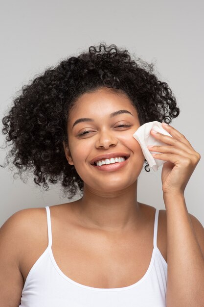 Retrato de una bella mujer quitando su maquillaje con un pañuelo