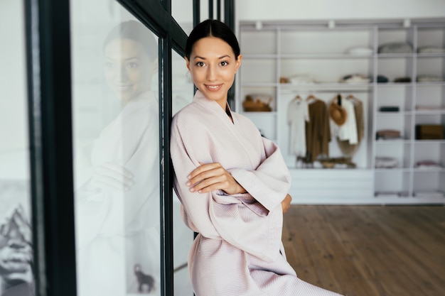 Retrato de una bella mujer sana en bata de baño posando en interiores