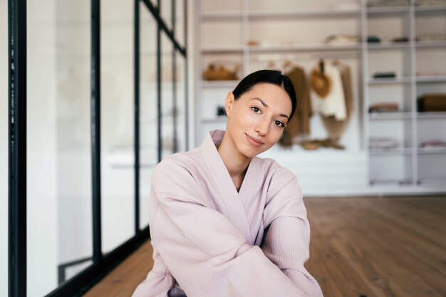 Retrato de una bella mujer sana en bata de baño posando en interiores