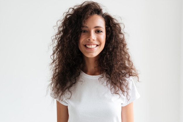 Retrato de una bella mujer sonriente con el pelo largo y rizado