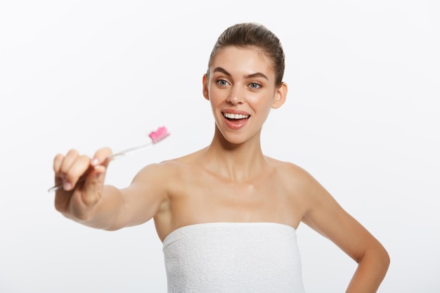 Retrato de belleza de una feliz y hermosa mujer semidesnuda cepillándose los dientes con un cepillo de dientes y looki