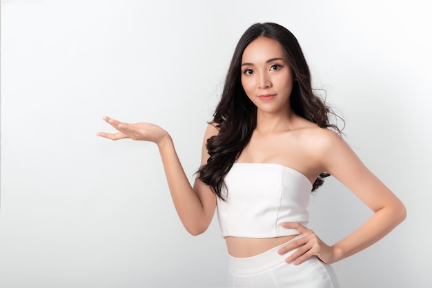 Retrato de belleza mujer asiática chica atractiva en moda posando con cara sonriente con vestido blanco sobre fondo blanco para medios cosméticos o saludables