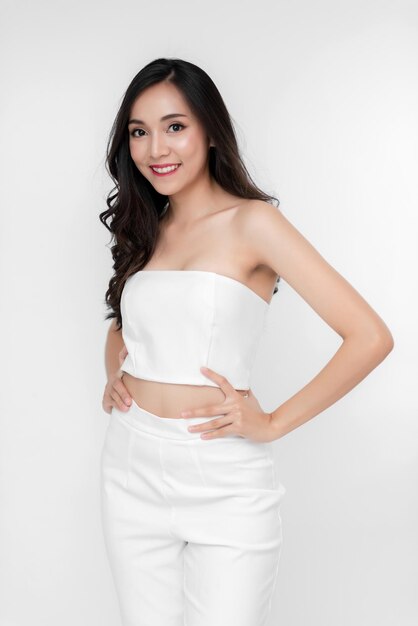 Retrato de belleza mujer asiática chica atractiva en moda posando con cara sonriente con vestido blanco sobre fondo blanco para medios cosméticos o saludables