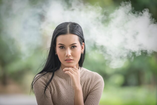 Retrato de belleza mujer joven sentada en el parque