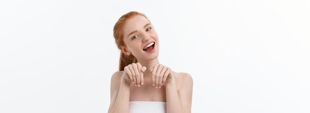 Retrato de belleza de una mujer joven sonriente mirando a la cámara aislada sobre fondo gris