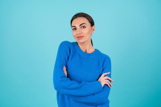 Retrato de belleza mujer joven en un suéter de punto azul y maquillaje de día natural, sonriendo alegremente, sonrisa romántica confiada