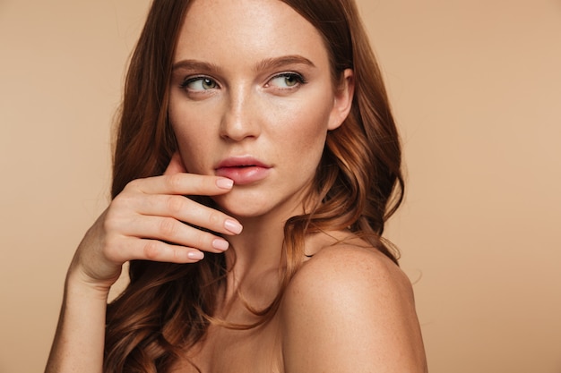 Retrato de belleza de mujer misteriosa jengibre con cabello largo posando de lado mientras mira lejos