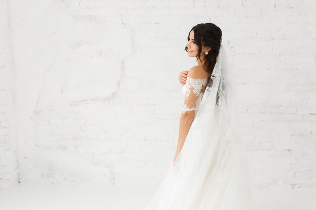 Retrato de la belleza de la novia con vestido de novia de moda con plumas