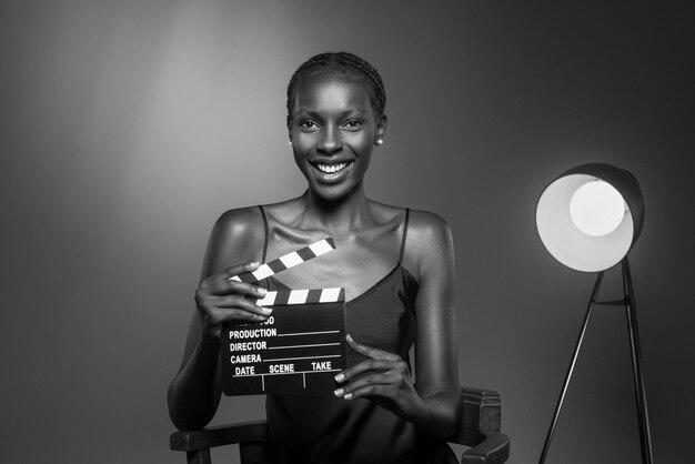 Retrato en blanco y negro de una mujer con claqueta al viejo estilo glamuroso de Hollywood