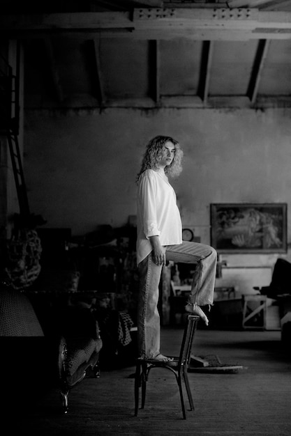 Foto gratuita retrato en blanco y negro de una mujer hermosa posando en el interior de una silla