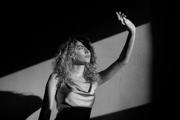 Retrato en blanco y negro de una mujer hermosa posando en el interior con un vestido