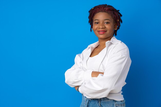 Retrato de bonita atractiva mujer afroamericana contra el fondo azul.