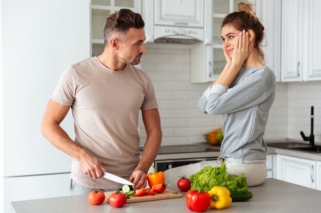 Retrato de una bonita pareja amorosa cocinar ensalada juntos