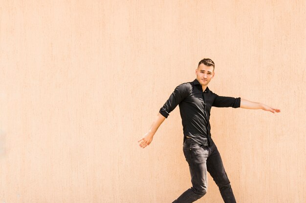 Retrato de breakdancer masculino joven contra la pared