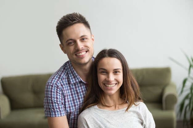 Retrato en la cabeza de una sonriente pareja milenaria atractiva mirando a la cámara