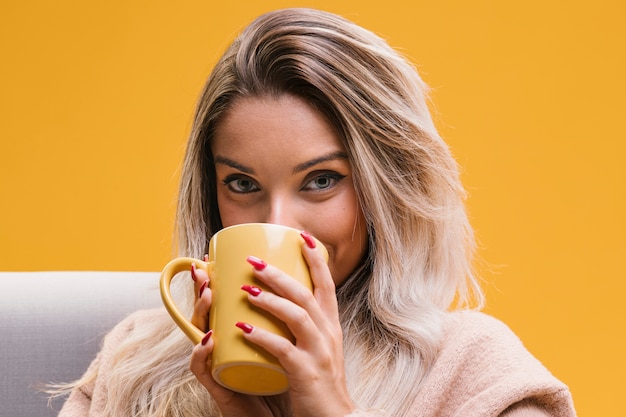 Retrato del café de consumición de la mujer joven en casa