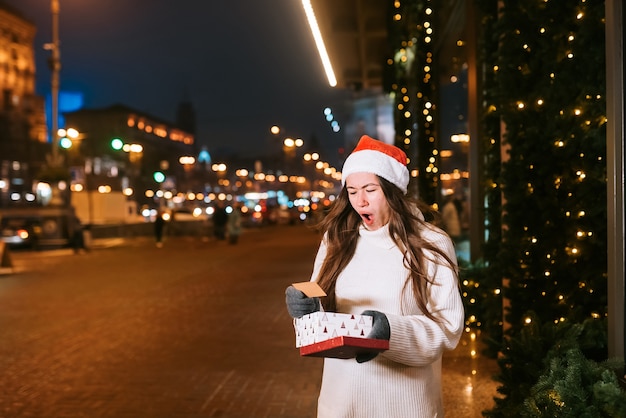 Retrato de calle de noche de joven bella mujer actuando emocionado