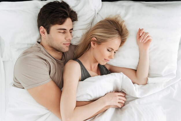Retrato de calma guapo pareja durmiendo en la cama
