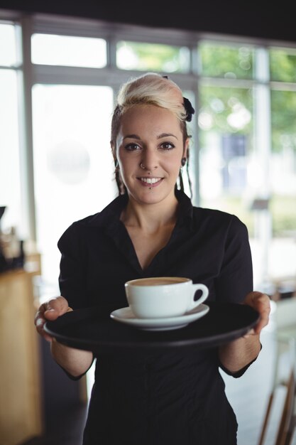 Retrato de camarera de pie con una taza de café