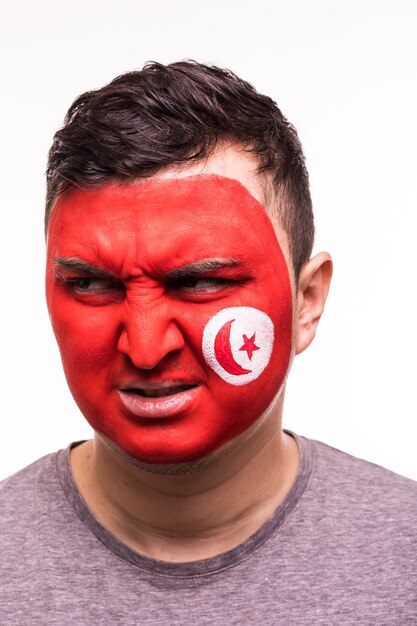 Retrato de la cara del apoyo del ventilador feliz equipo nacional de Túnez con la cara pintada aislado sobre fondo blanco.