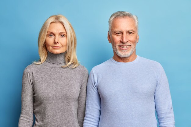 Retrato de cariñoso esposo y esposa ancianos vestidos con ropa casual miran con confianza al frente