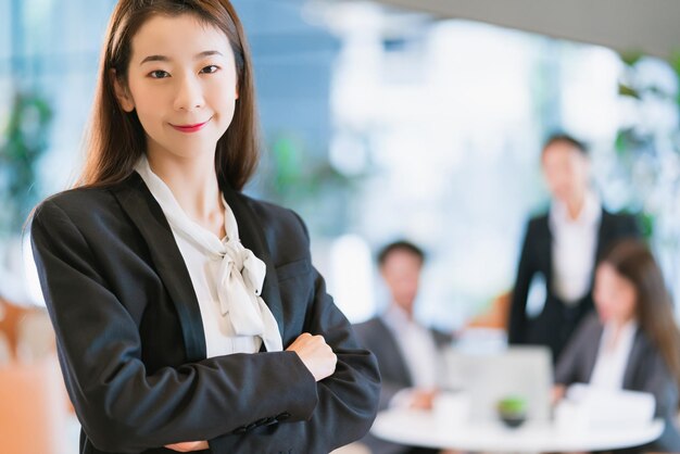 Retrato de cerca inteligente y atractiva sonrisa femenina de negocios asiáticos con confianza y liderazgo en el fondo de la oficina moderna