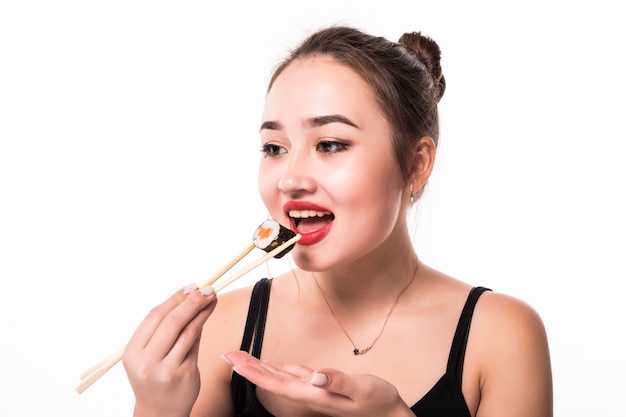 Retrato cercano de una mujer hermosa que come los rollos de sushi