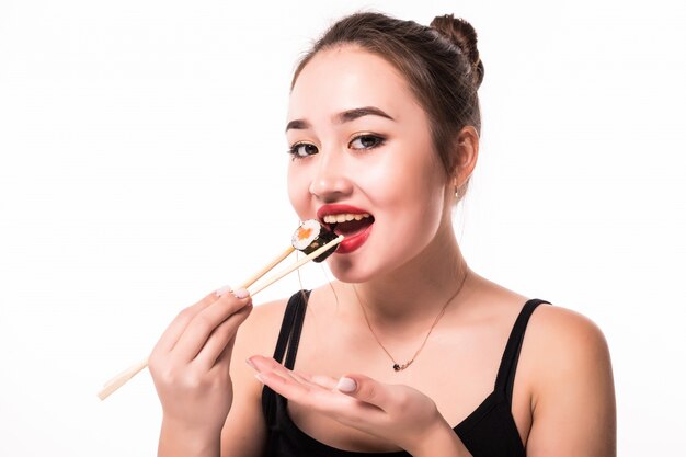 Retrato cercano de una mujer hermosa que come los rollos de sushi