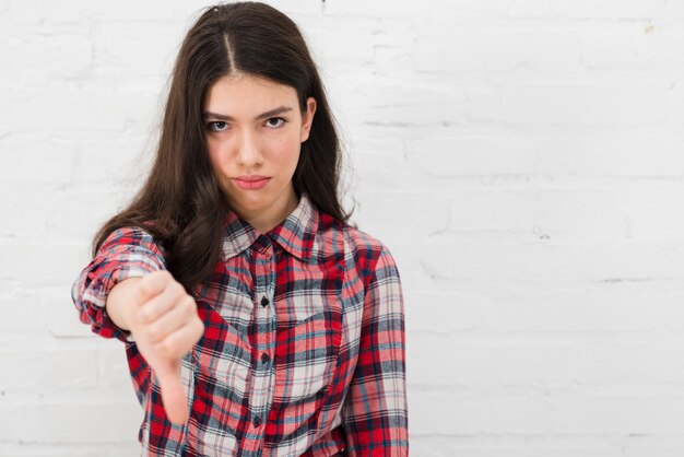 Retrato de chica adolescente con pulgar abajo