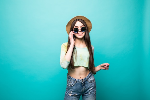 Retrato de una chica encantadora, fresca, bonita y sexy con gafas negras, sosteniendo un teléfono inteligente cerca de la oreja, hablando con amigos, recibiendo una llamada de su amante, aislado