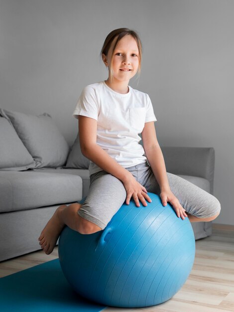 Retrato chica entrenamiento con pelota en casa