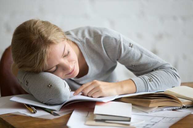 Retrato de una chica estudiante durmiendo en el escritorio