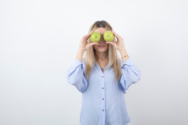 retrato de una chica guapa modelo de pie y sosteniendo manzanas frescas.