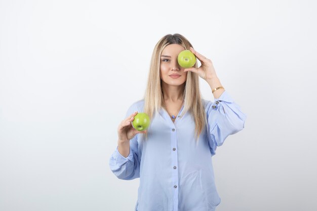 retrato de una chica guapa modelo de pie y sosteniendo manzanas frescas.