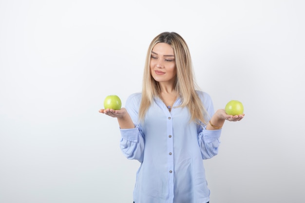 retrato de una chica guapa modelo de pie y sosteniendo manzanas frescas.