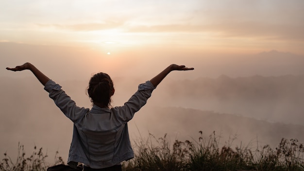 Retrato. chica tira sus manos hacia el sol. sobre el volcán batur. Bali, Indonesia