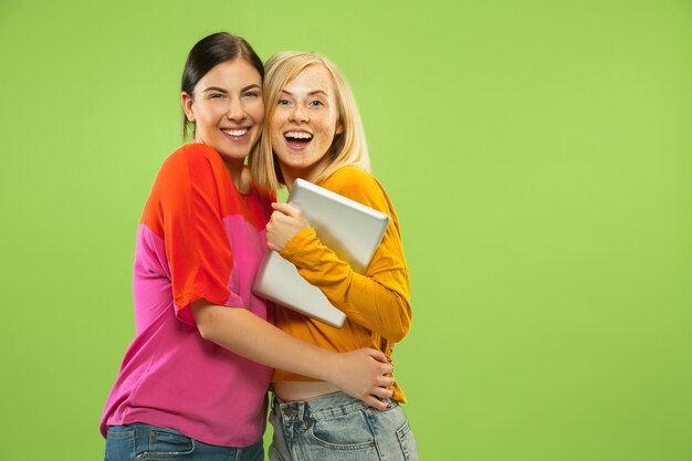 Retrato de chicas muy encantadoras en trajes casuales aislados en verde