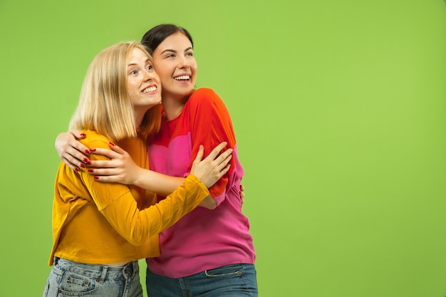 Retrato de chicas muy encantadoras en trajes casuales en estudio verde